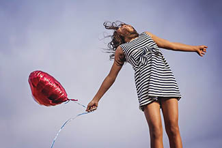 eye healthy female with a red heart balloon